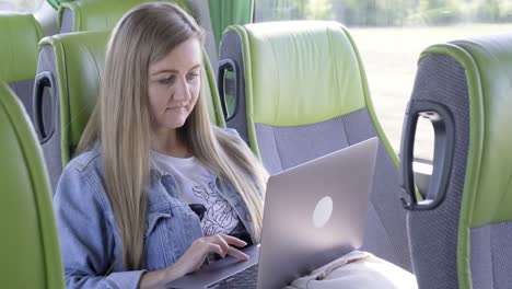 Woman using laptop on a bus