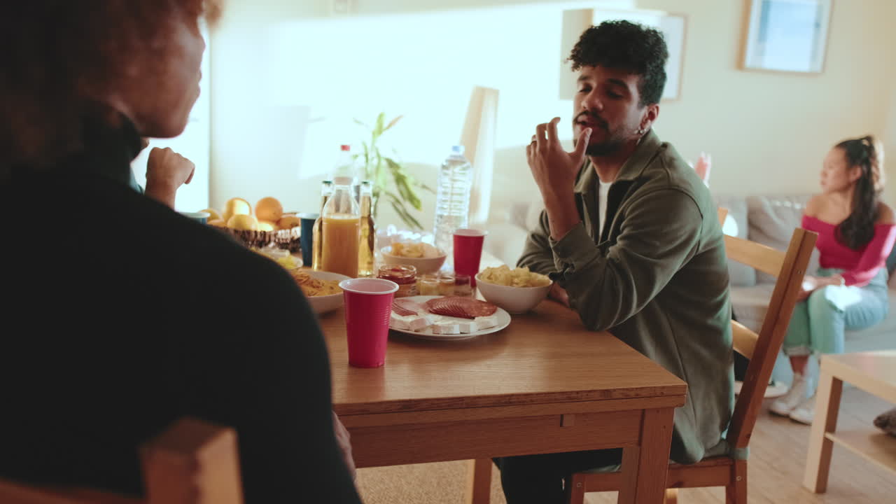 Group of friends gathering for a party, having a conversation around the table