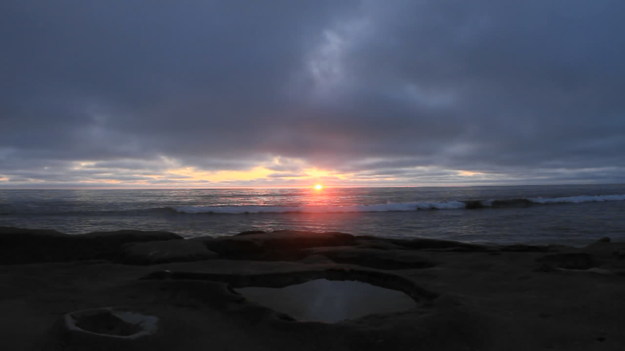 las olas llegan a la playa justo después del atardecer 2