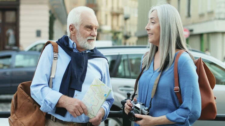 Ritratto di una coppia di anziani con una mappa in piedi nel centro della città che conversano