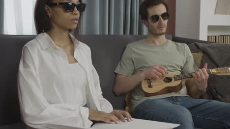 close up view of blind friends sitting on a sofa in a flat