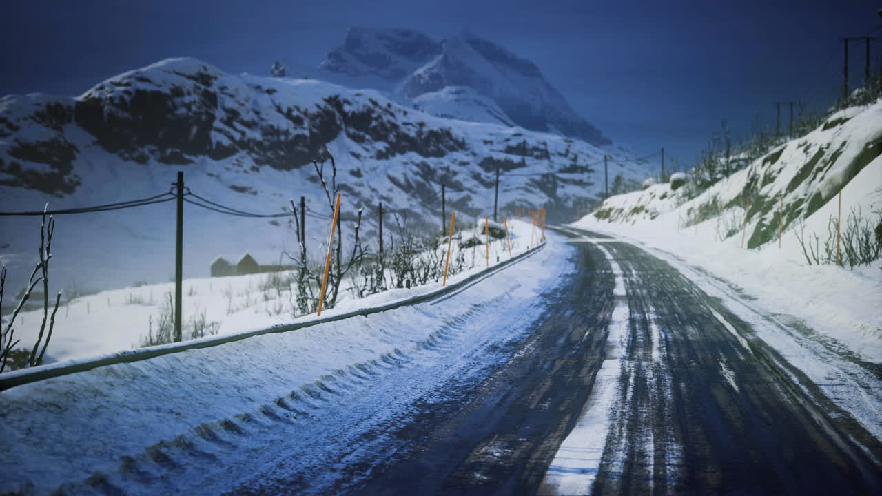Winter road winding through snow covered mountains at dusk
