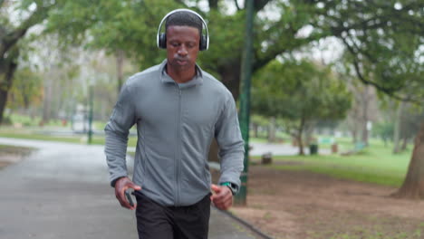 man jogging and using phone in park