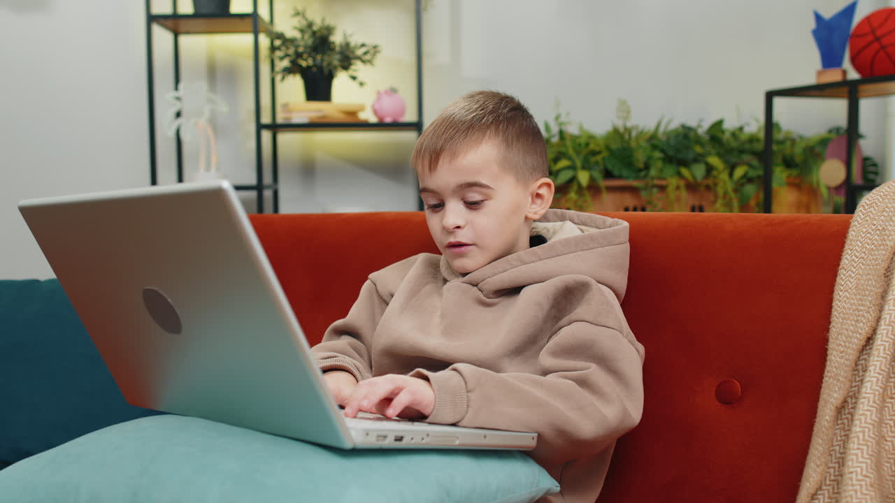 Preteen child boy looking at laptop camera making video webcam conference call with friends family