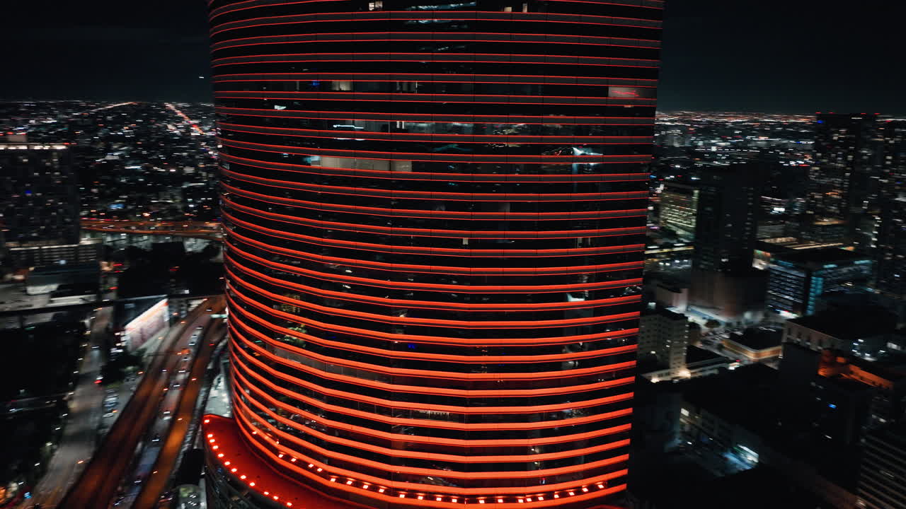 Vista aerea notturna della Miami Tower illuminata con luci LED rosse. Skyline moderno del centro con densità urbana, architettura di grattacieli e vivace atmosfera cittadina.