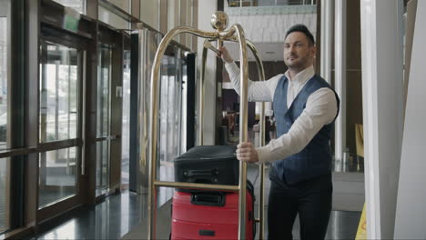 hotel bellhop with luggage in lobby
