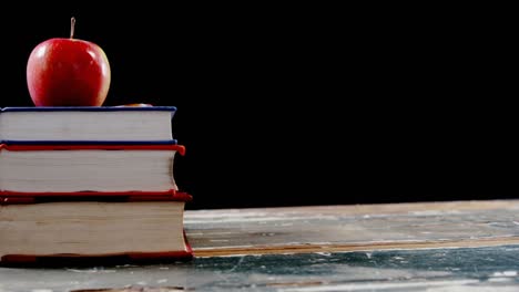 red apple on book stack