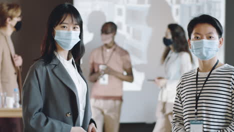 회의 에서 마스크 를 쓴 두 명 의 아시아 사업가 의 초상화