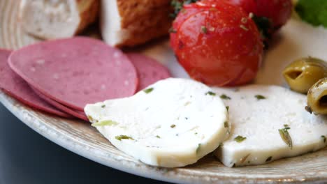 appetizer platter with cheese, tomatoes, olives, and sausage