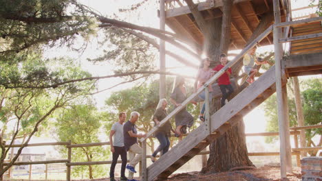 Mehrgenerationenfamilie-Klettert-Auf-Holzplattform-Im-Freien-Zum-Baumhaus-Im-Garten