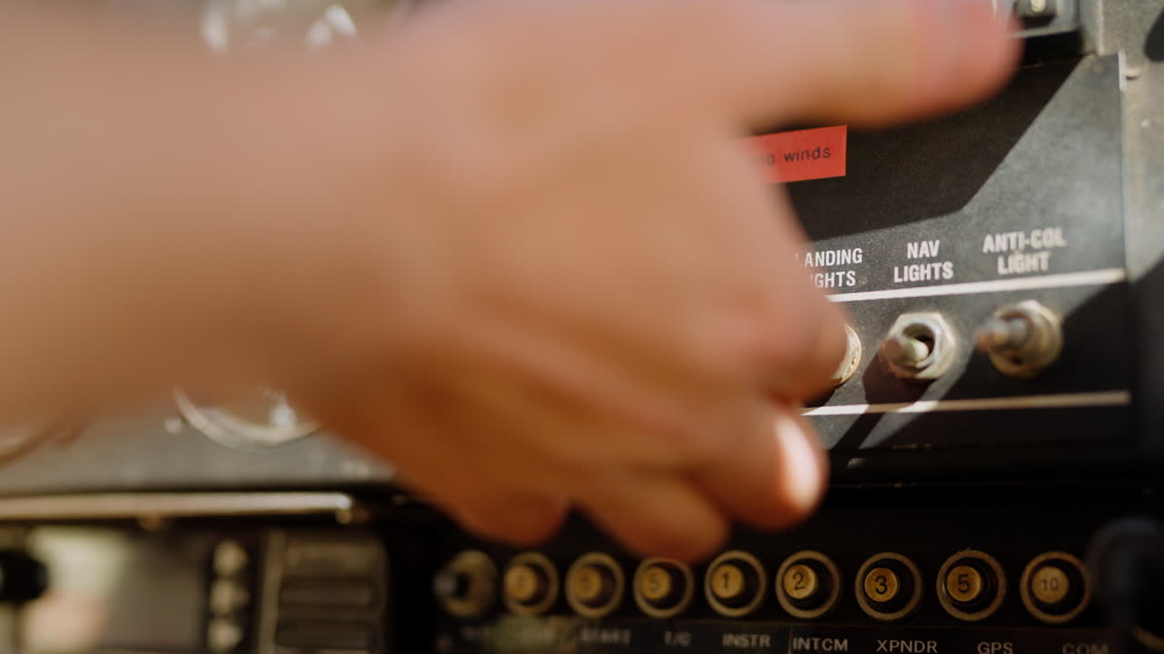 Pilot's Hand Operating Switches on Airplane Control Panel
