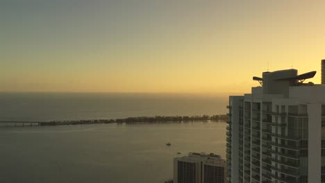cinematic aerial shot of iconic building in brickell drive in miami florida at sunset during golden hour