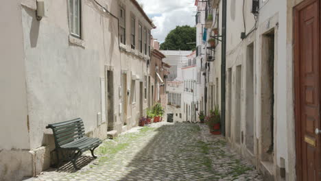 a quiet narrow alleyway in alfama, one of the oldest neighborhoods in lisbon, portugal