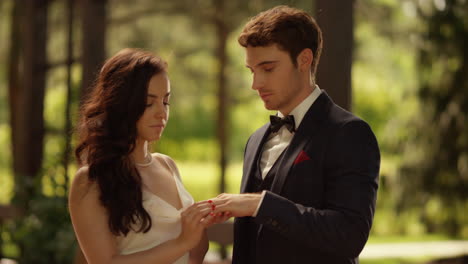 couple standing in garden. newlywed man and woman getting married in park