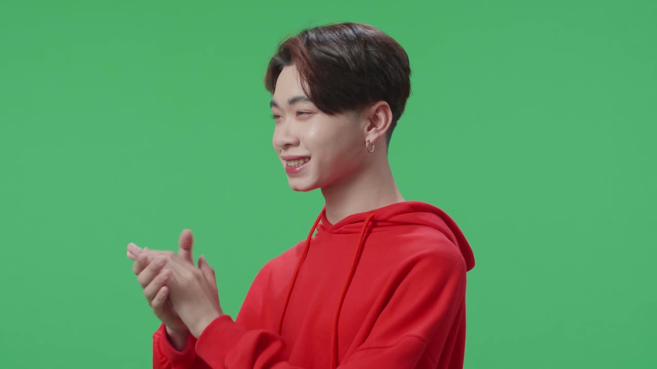 Side View Of Young Asian Transgender Male Clapping Her Hands In The Green Screen Studio