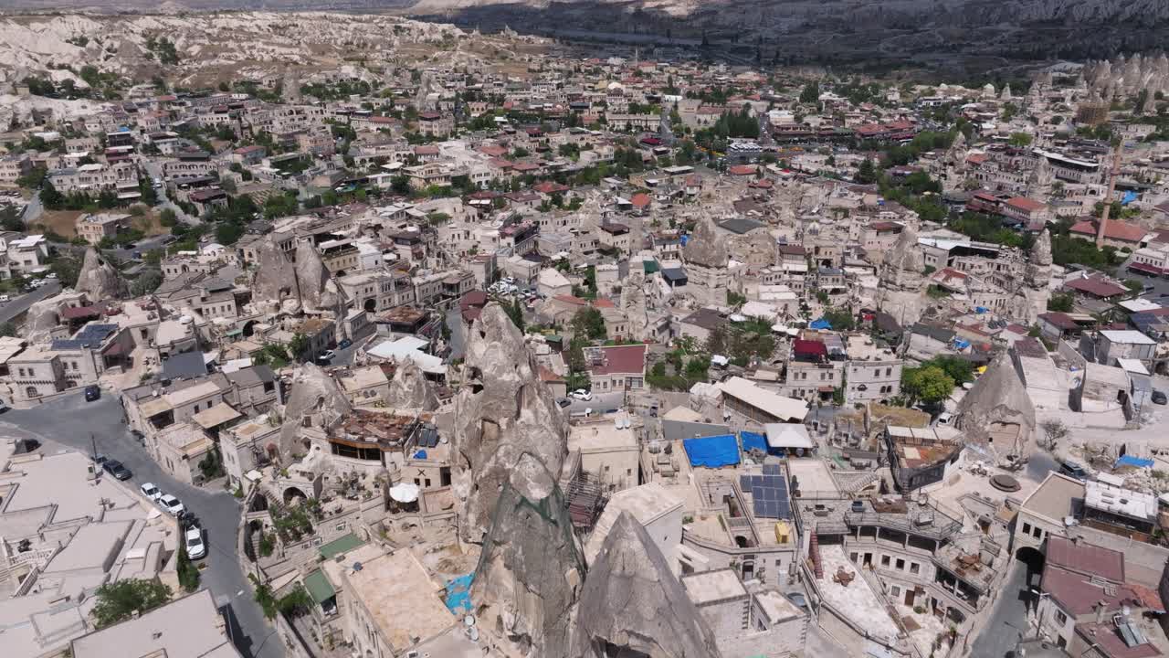 Establishing aerial dolly above Cappadocia Turkey at midday with cloud shadow on stone spires