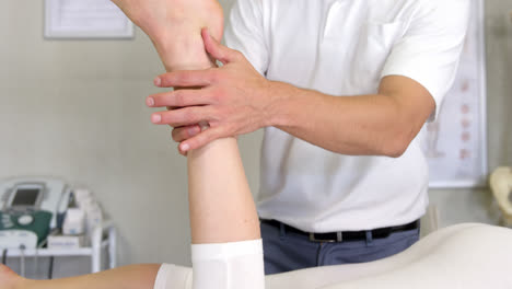 male physiotherapist giving leg massage to female patient