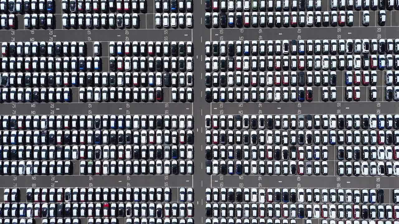 High aerial drone footage of car export and customs terminal with lined vehicles and logistics operations in Grimsby England UK