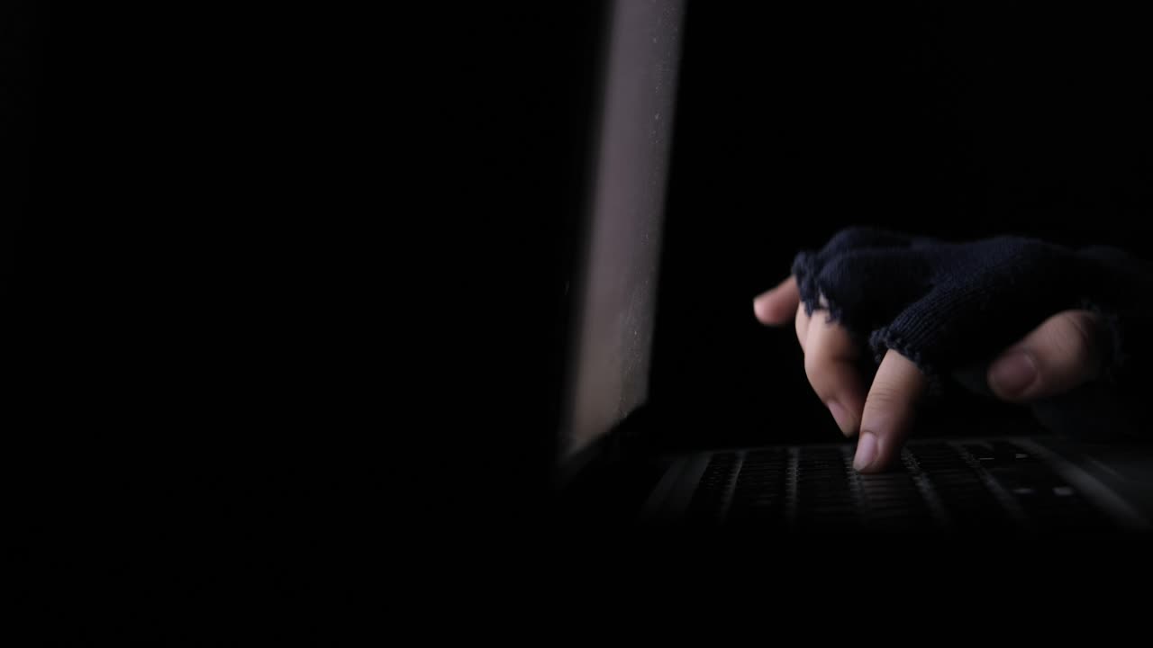 Hacker using laptop at night