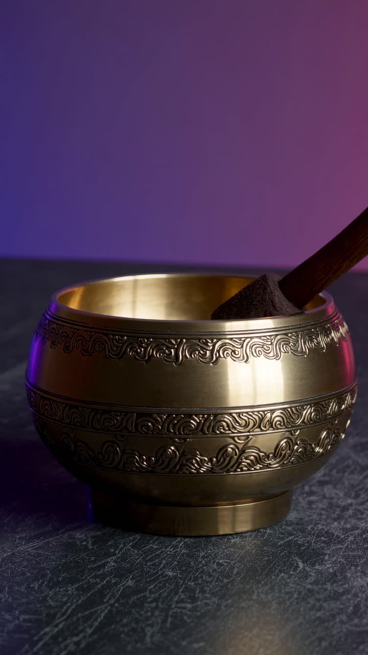A close-up video of a decorative brass bowl with intricate patterns, shot from a side angle video