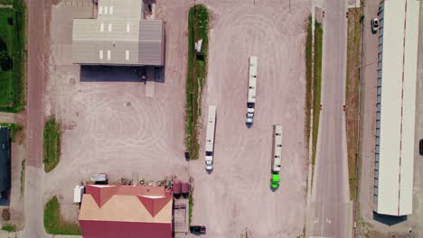 aerial view from above showing three livestock trailers with trucks parked in an industrial parking lot