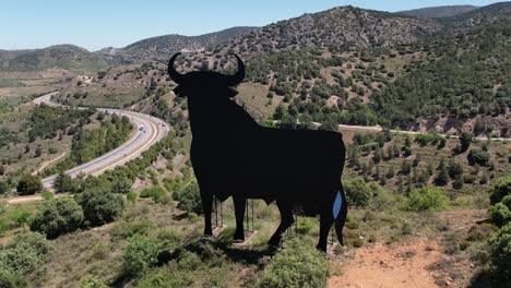 Drone-Ver-Vuelo-Hacia-Atrás-Del-Toro-Symbil-De-España-De-Osborne,-Un-Icono-Nacional