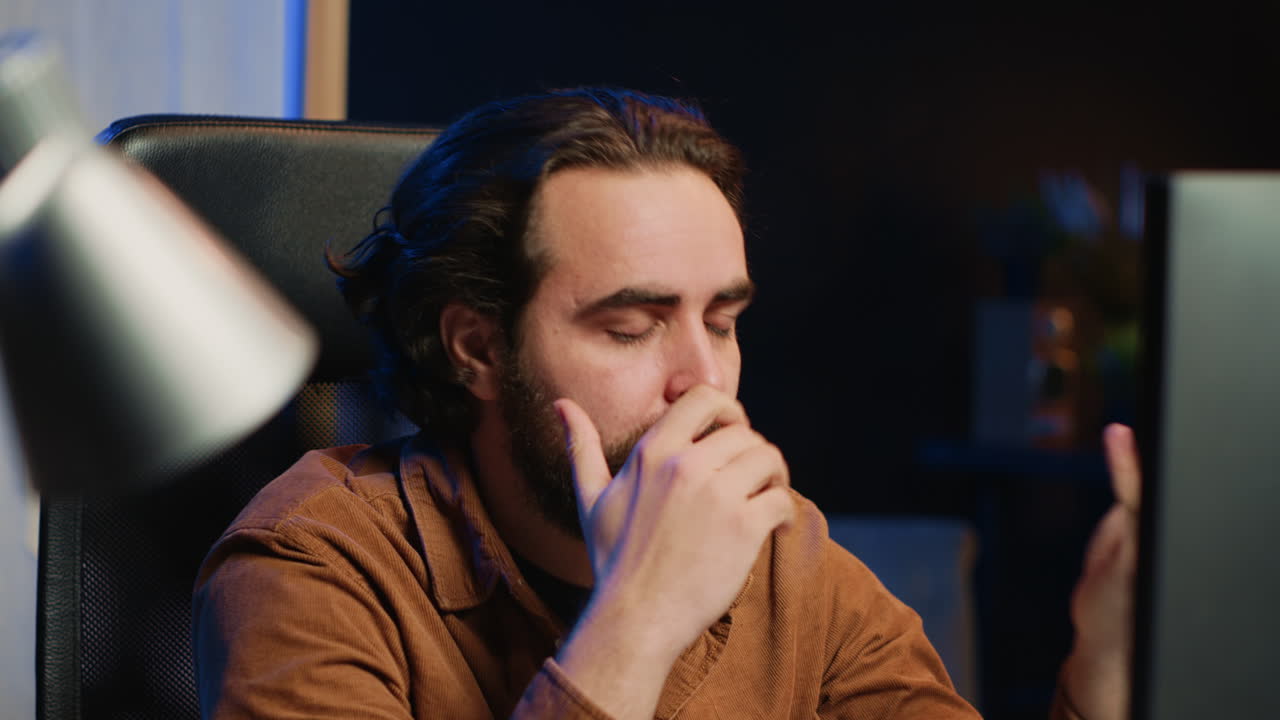 Teleworking IT professional smashing desk, irritated by coding errors