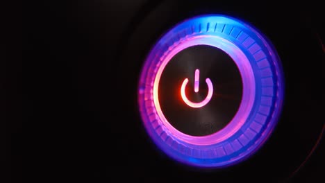 4k macro video loop of a lightning-up computer power button on the system unit on a black background.