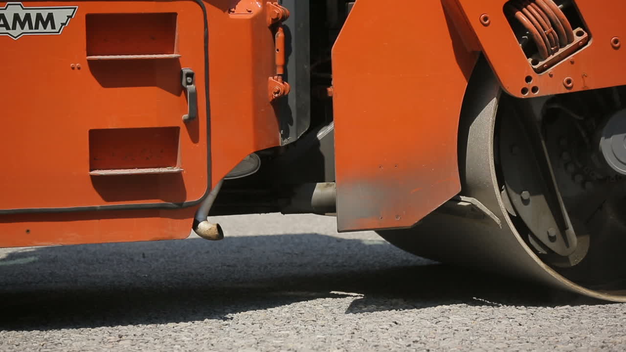 Road Roller Working On A Gravel. Road roller laying gravel during road construction
