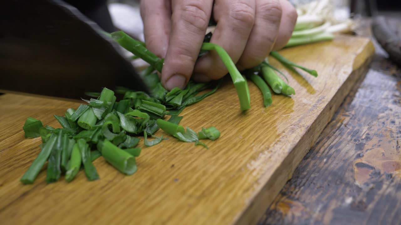 Finely chopped green onions with a hand-made chef's knife. Finely chop the green onions outdoors