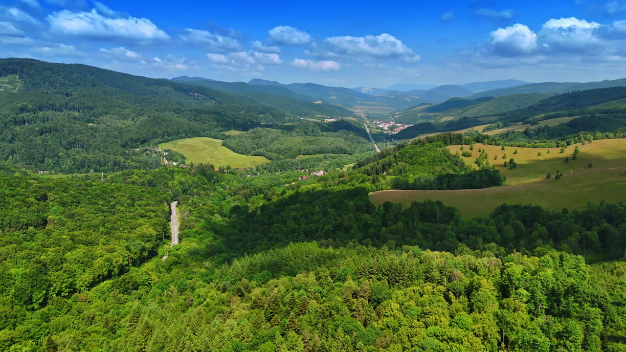 Lush green landscape with rolling hills. Vibrant greenery covers rolling hills under a clear blue sky in a picturesque rural area during daytime