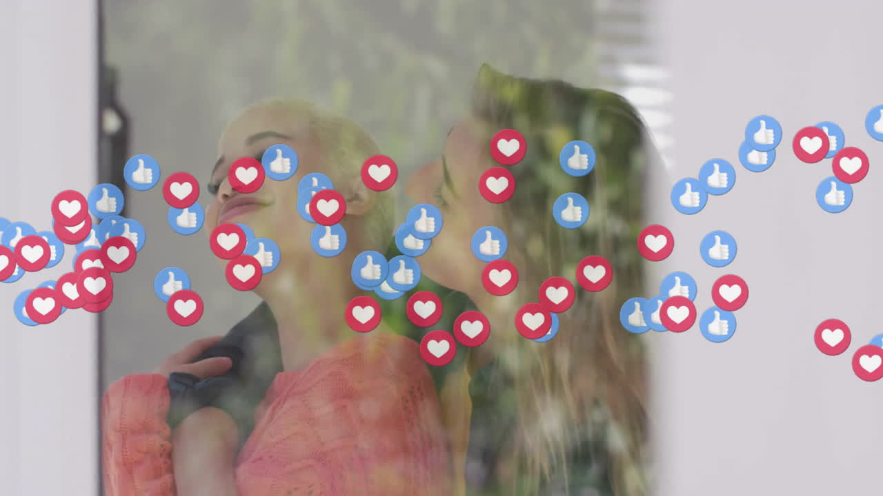 Two women leaning behind glass, interacting with floating thumbs-up and heart icons for marketing