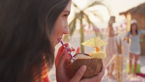 caucasian woman drinking a cocktail on the beach