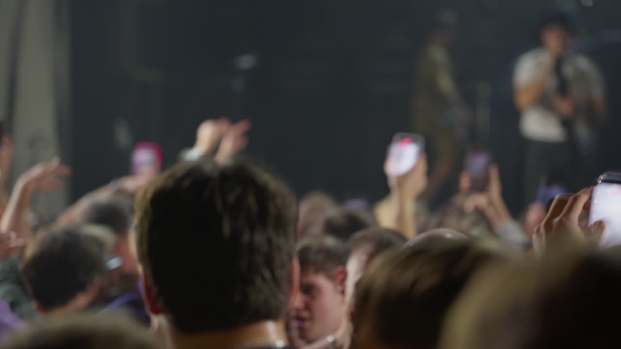 Folla a un concerto che registra un'esibizione dal vivo con smartphone
