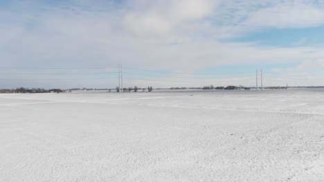 heavy snow covering countryside fields and electricity power lines