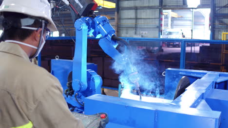 Robotic Arm With Torch Welding Steel In A Fabrication Plant. dolly-in