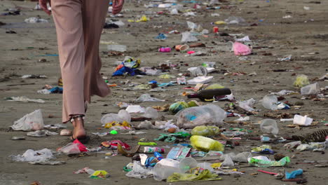 Niña-Camina-A-Orillas-Del-Mar-Con-Basura-Plástica---Playa-Contaminada-En-Mui-Ne,-Binh-Thuan,-Vietnam