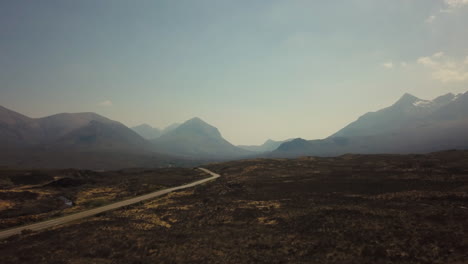 drone shot of mountains and road in skye island