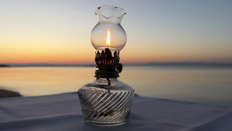 lámpara de aceite de mesa vintage contra el telón de fondo de la puesta de sol