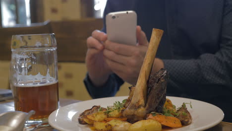 man with phone making photo of a served dish