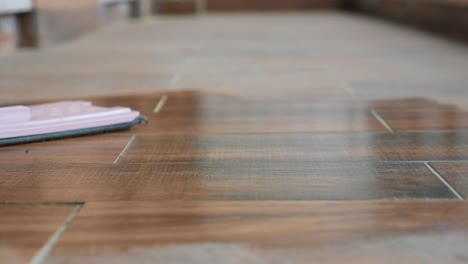 cleaning a wooden tile floor with a mop