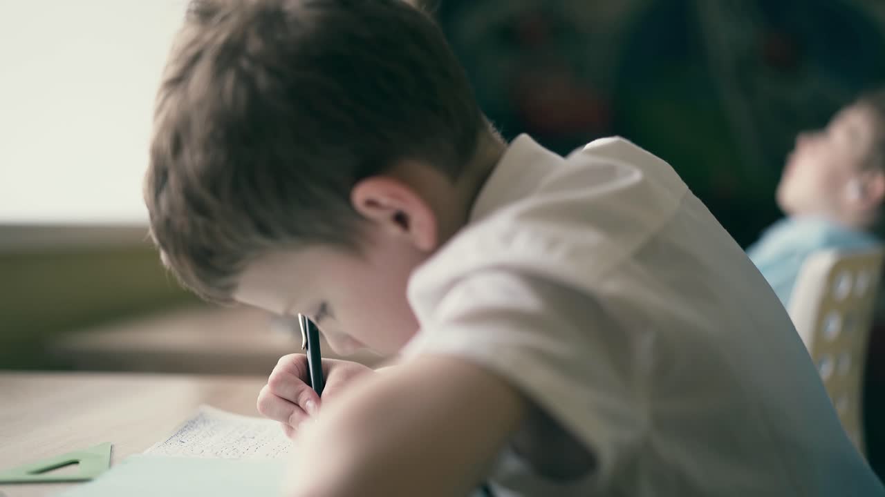 슬로우 모션 아이들이 숙제를 하고 오디오북을 듣고 있습니다.