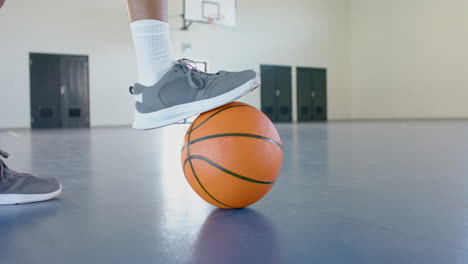 person plays basketball indoors