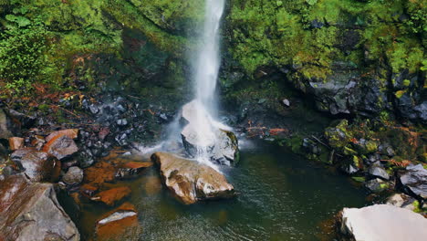 waterfall stream crashing rocks aerial view. force water falling mossy cliff