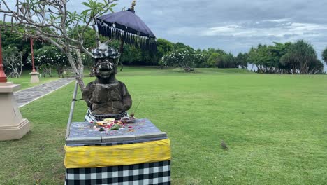 Lush-green-park-with-hindu-God-statue,-flowers-and-food-as-sacrifice-offering