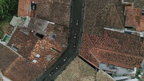 drone footage of a gorup of horses croosing the streets of a city, minas gerais, brazil