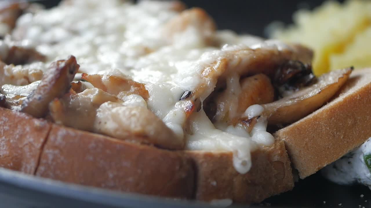 Närbild på ostig svamp- och kycklingtoast