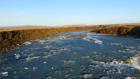 vista aérea de la cascada congelada de urriðafoss en islandia con el río salvaje