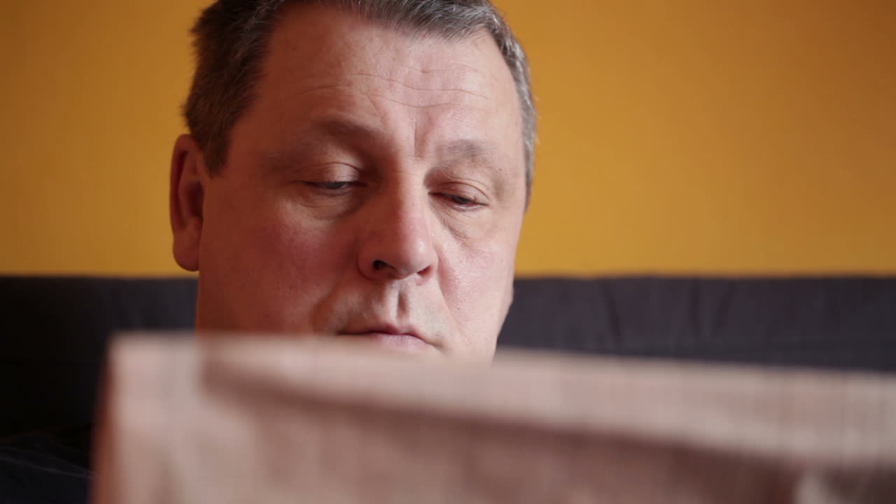 중년 남자가 금융 뉴스를 읽습니다.