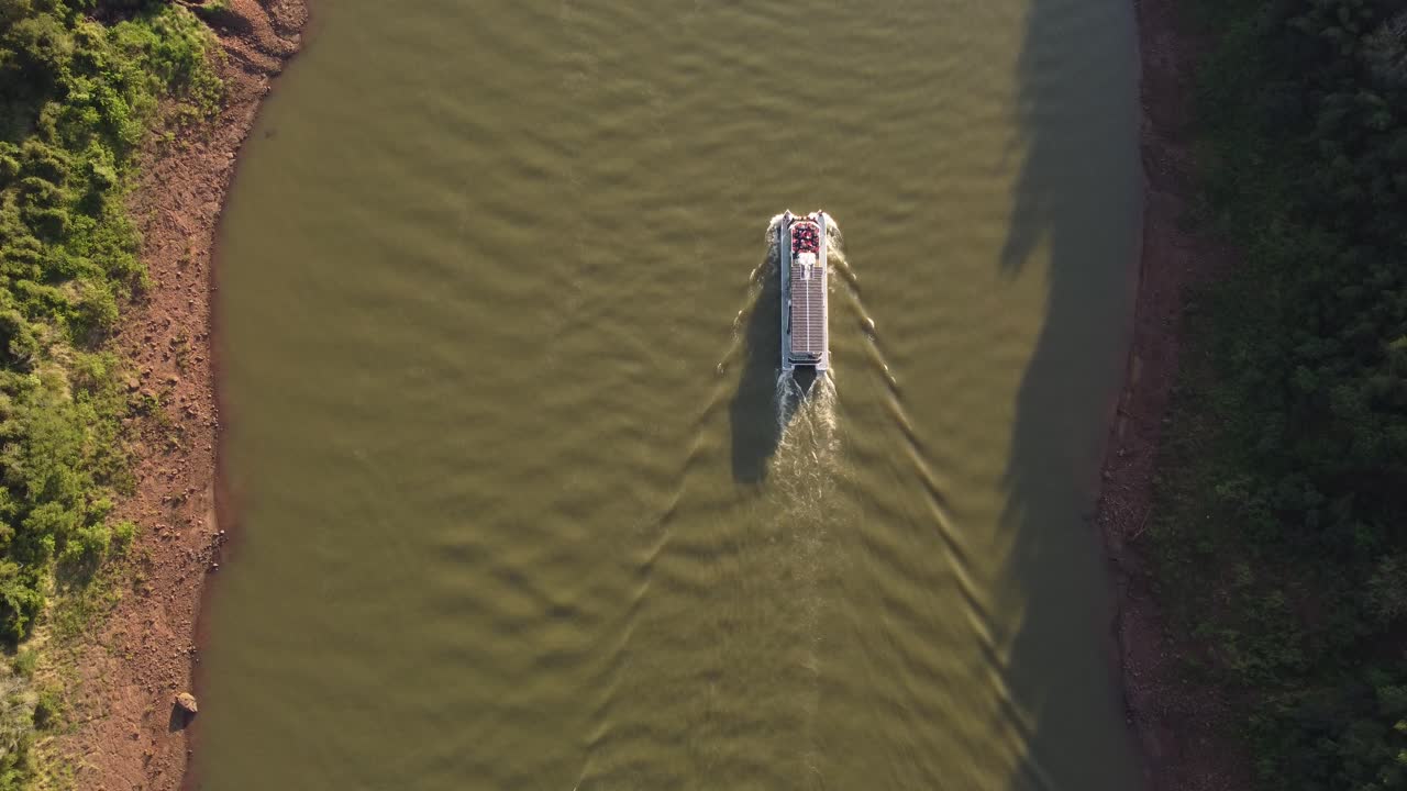 barco turístico a lo largo del río iguazú al anochecer, frontera entre argentina y brasil